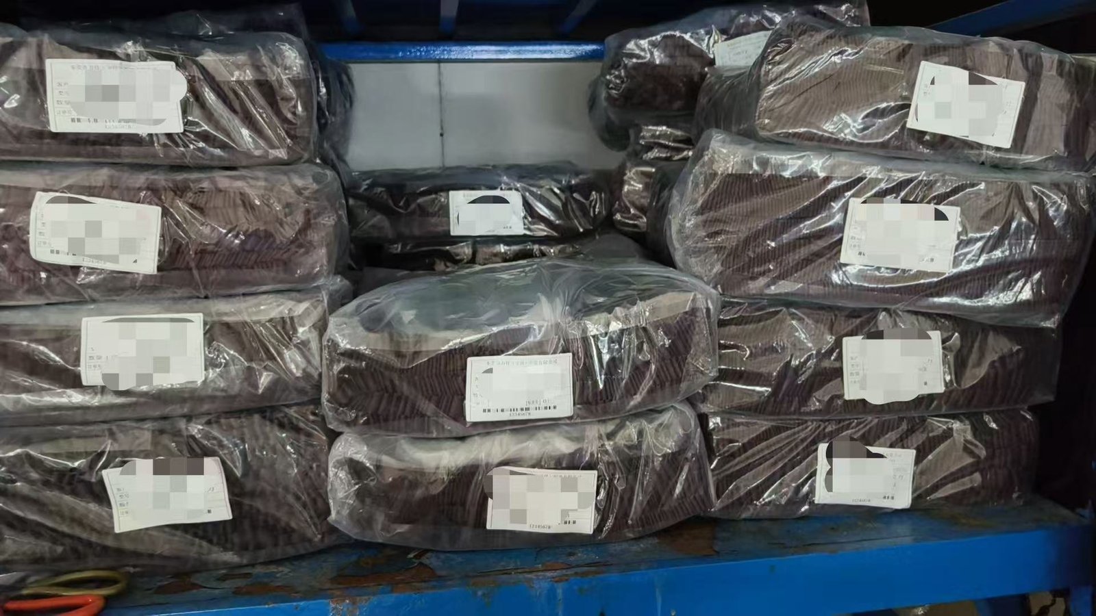 Material stock on warehouse shelves, wrapped in film and ticketed