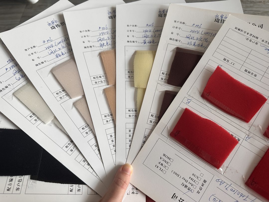 Lab-dip colour cards held in hand for approval before bulk dyeing