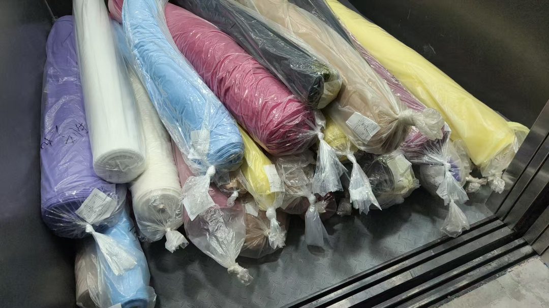 Rolled fabrics in storage, wrapped and labelled, at the Alvira Lingerie workshop in Dongguan