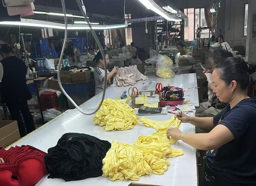 Finishing table in the Alvira Lingerie workshop: threads trimmed and finished bras checked piece by piece before packing