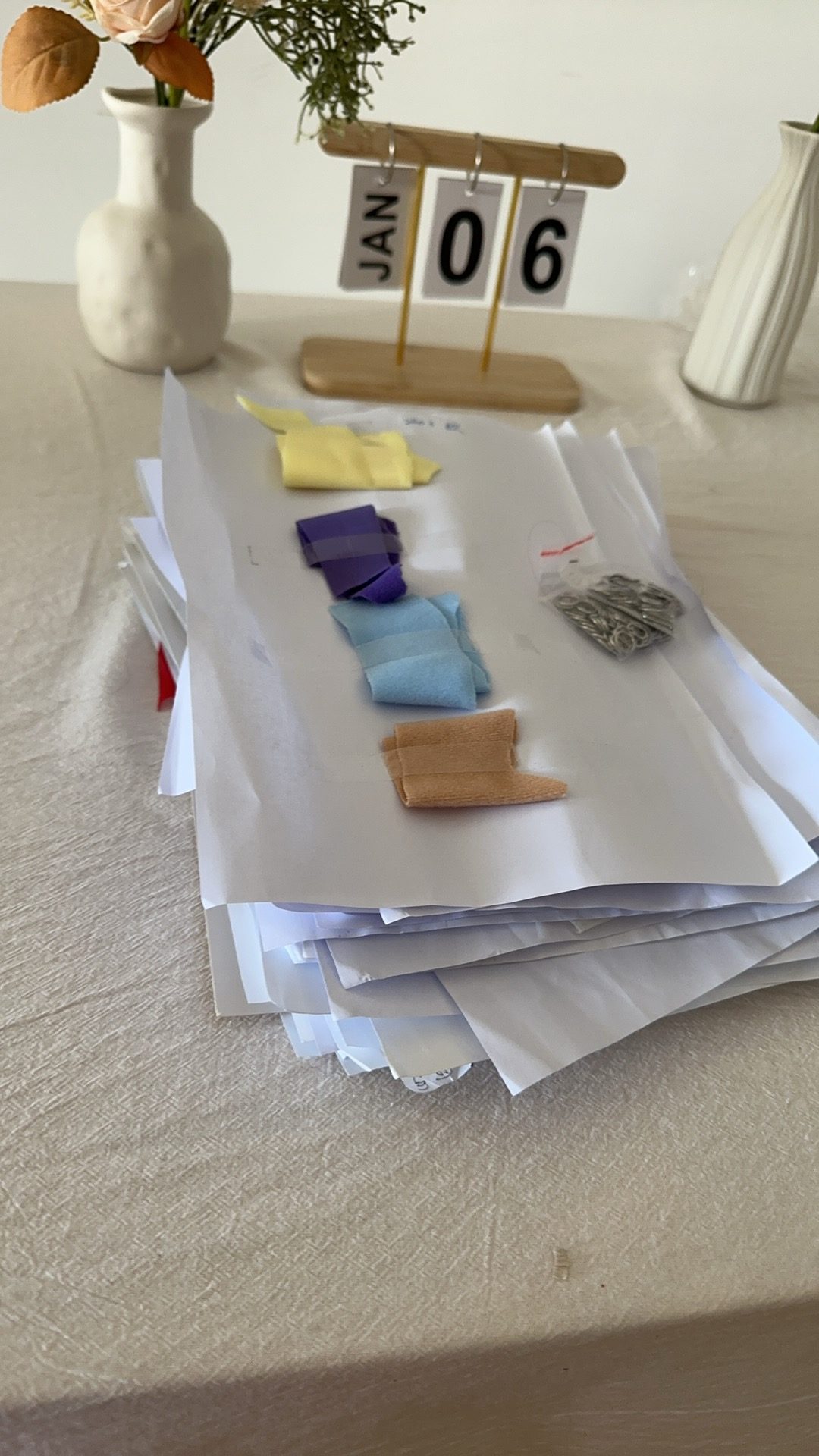 Fabric swatches and trims matched to the tech pack on a table